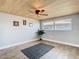 Bright living room with hardwood floors, wood plank ceiling, ceiling fan, and lots of natural light at 5509 Pilots Pl, New Port Richey, FL 34652