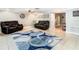 Bright living room with neutral walls, ceiling fan and tile floors and comfortable, dark leather sofas at 5509 Pilots Pl, New Port Richey, FL 34652