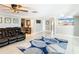 Bright living room with neutral walls, ceiling fan and tile floors and comfortable, dark leather sofas at 5509 Pilots Pl, New Port Richey, FL 34652