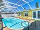 Beautiful screened-in pool with clear blue water and stainless steel ladder for easy access on a sunny day at 5509 Pilots Pl, New Port Richey, FL 34652
