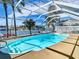 Screened-in pool with canal view, palm trees, and plenty of space for relaxation at 5509 Pilots Pl, New Port Richey, FL 34652