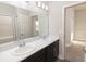 Well-lit bathroom boasts dual sinks, spacious countertop, and a large mirror over dark cabinetry at 6058 Barracuda Loop, Wimauma, FL 33598