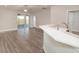 Open-concept living room showcasing sleek flooring and access to outdoor lanai through sliding glass doors at 6058 Barracuda Loop, Wimauma, FL 33598