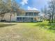 Large backyard features a two-story house with a screened-in porch perfect for enjoying the outdoors at 11175 Hyde St, Weeki Wachee, FL 34614