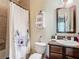 Bright bathroom featuring a granite vanity, mirror, a toilet, and a shower with a floral shower curtain at 11175 Hyde St, Weeki Wachee, FL 34614