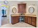 Bathroom with double sink vanity, granite countertop, and decorative mirrors at 11175 Hyde St, Weeki Wachee, FL 34614