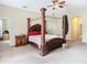 Spacious bedroom featuring a wooden canopy bed with red pillows and floral comforter at 11175 Hyde St, Weeki Wachee, FL 34614