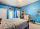 Bedroom showcasing blue walls, ceiling fan, and walk-out access to balcony at 11175 Hyde St, Weeki Wachee, FL 34614