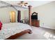 Spacious bedroom with a canopy bed frame, neutral carpeting, and a walk-through to the ensuite bathroom at 11175 Hyde St, Weeki Wachee, FL 34614