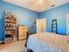 Bedroom featuring blue walls, ceiling fan, storage shelves, and ladder at 11175 Hyde St, Weeki Wachee, FL 34614