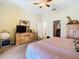 Cozy bedroom featuring a ceiling fan, plush carpeting, a wooden dresser with mirror, and neutral walls at 11175 Hyde St, Weeki Wachee, FL 34614