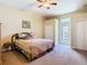 Neutral bedroom featuring a ceiling fan, double door closet, plush carpeting, and a door to the outside at 11175 Hyde St, Weeki Wachee, FL 34614