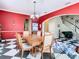 Elegant dining room showcasing bold red walls, traditional wood table and chairs and an ornate chandelier at 11175 Hyde St, Weeki Wachee, FL 34614