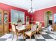 Inviting dining room features red accent wall, large windows, and access to hall and connecting rooms at 11175 Hyde St, Weeki Wachee, FL 34614