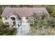 Aerial view of a charming two-story home with a three-car garage and a well-manicured lawn in a wooded area at 11175 Hyde St, Weeki Wachee, FL 34614
