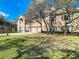 Charming two-story home with three-car garage, manicured front lawn, white fence and landscaping at 11175 Hyde St, Weeki Wachee, FL 34614