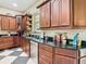 Kitchen with dark wood cabinets, granite countertops, stainless steel appliances, and checkered tile floors at 11175 Hyde St, Weeki Wachee, FL 34614