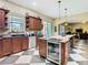 Spacious kitchen featuring dark wood cabinetry, stainless steel appliances, granite counters, and checkered floors at 11175 Hyde St, Weeki Wachee, FL 34614