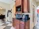 Cozy kitchen featuring wooden cabinets, granite counters, and stainless appliances near a checkered tile floor at 11175 Hyde St, Weeki Wachee, FL 34614