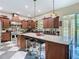 Chef's kitchen equipped with custom cabinetry, granite counters and a central island with seating at 11175 Hyde St, Weeki Wachee, FL 34614