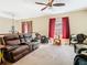 Inviting upstairs living room with a leather sofa and ceiling fan at 11175 Hyde St, Weeki Wachee, FL 34614