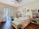 Bright main bedroom with a ceiling fan, floral bedding, wood floors, and sliding glass doors to a lanai at 11175 Hyde St, Weeki Wachee, FL 34614