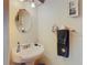 Compact powder room featuring a pedestal sink, wall-mounted mirror, and classic fixtures at 11175 Hyde St, Weeki Wachee, FL 34614