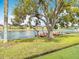 Waterfront property featuring a private dock, lush green lawn, and beautiful water views at 4745 Floramar Ter, New Port Richey, FL 34652