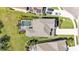 Aerial shot of a well-maintained home, pool, and surrounding lush green lawn at 7048 White Willow Ct, Sarasota, FL 34243