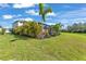 Lush green lawn and tropical landscaping surround the screened-in pool area at 7048 White Willow Ct, Sarasota, FL 34243