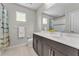 Bright bathroom featuring a double vanity, large mirror, and shower with decorative tile accents at 7048 White Willow Ct, Sarasota, FL 34243