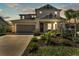 Charming two-story home with a well-manicured lawn and inviting front porch at dusk at 7048 White Willow Ct, Sarasota, FL 34243