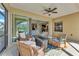 Inviting screened lanai features wicker seating around a small table and fan, creating a relaxing retreat at 7048 White Willow Ct, Sarasota, FL 34243