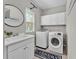 Well-lit laundry room featuring a sink, washer, dryer, and ample cabinet space at 7048 White Willow Ct, Sarasota, FL 34243