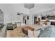 Bright and airy living room leading to the kitchen area with barstool seating at the kitchen island at 7048 White Willow Ct, Sarasota, FL 34243