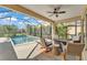 An inviting screened-in pool area with a covered patio featuring cozy seating and a clear view of the pool and backyard at 7048 White Willow Ct, Sarasota, FL 34243