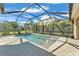 An enclosed pool area features a clear, blue pool with a sun deck, surrounded by a screened enclosure at 7048 White Willow Ct, Sarasota, FL 34243