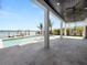 Large tiled patio with an outdoor pool offering an unobstructed view of the adjacent waterway and boat dock at 820 Bay Point Dr, Madeira Beach, FL 33708