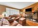 Charming living room with a brick fireplace, wood wall, and a comfortable leather sofa set at 1000 Michigan Blvd, Dunedin, FL 34698
