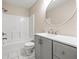 Bathroom featuring white tile shower/tub, gray cabinets and a round mirror at 1112 21St E St, Palmetto, FL 34221