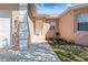 Close-up of the front entrance with freshly manicured garden beds, neutral toned stucco and decorative white trim at 1112 21St E St, Palmetto, FL 34221