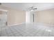 Spacious living room with pristine white tile floors, ceiling fan and neutral paint, flowing into other rooms at 1112 21St E St, Palmetto, FL 34221