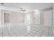 Bright, open-concept living room showcasing white tile floors, ceiling fan, and access to multiple rooms at 1112 21St E St, Palmetto, FL 34221