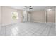 Well-lit living room features sleek white tile flooring, ceiling fan, and inviting doorways to other spaces at 1112 21St E St, Palmetto, FL 34221