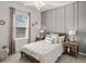 Comfortable bedroom with natural light, featuring a queen-size bed, stylish nightstands, and modern decor at 2432 White Ladyfish Rd, Wimauma, FL 33598