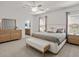Spacious main bedroom with a large bed, side tables, and an entrance to the main bathroom at 2432 White Ladyfish Rd, Wimauma, FL 33598
