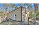 Exterior angle view of a neutral toned metal shed, complete with a side gate and small garden area at 27231 Snapper Creek Ln, Wesley Chapel, FL 33544