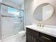 Bathroom featuring a glass enclosed shower, decorative mirror, and dark wood vanity at 2932 Sky Blue Cv, Bradenton, FL 34211