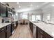 Contemporary kitchen with stainless appliances, dark cabinets, large island and dining area at 6022 Mangrove Creek Rd, Wimauma, FL 33598
