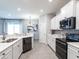 Modern kitchen featuring stainless steel appliances, white cabinets, and ample counter space at 6062 Barracuda Loop, Wimauma, FL 33598